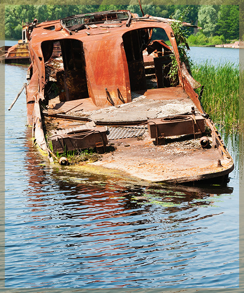 Old, rusted ferry boat sinking in water
