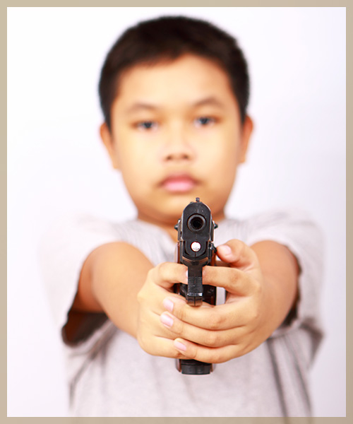Kid pointing gun with finger on trigger