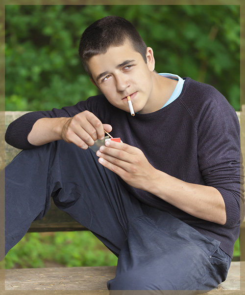 Kid sitting on a bench and smoking a cigarette