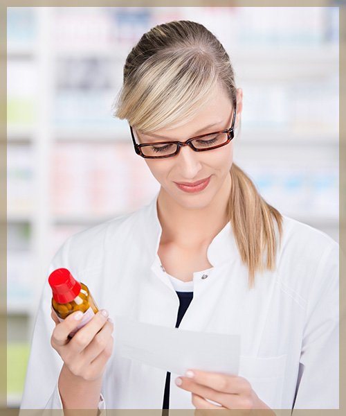 Pharmacist looking at prescription and pill bottle
