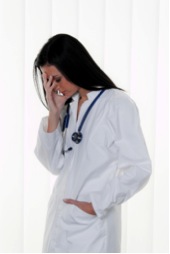 Female doctor looking stressed and holding face in hand
