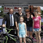 Children and parents posing in front of bike with Scott Goodwin at Law Day event