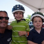 Man Poses with Children with Helmets