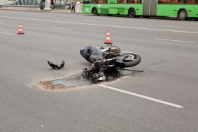 Smashed motorcycle after an accident with gas leaking out