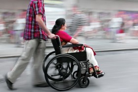 Man pushing woman in a wheelchair