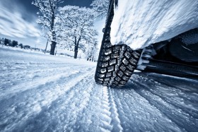 Car wheel driving through snowy road