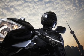 Biker dressed in black leather while riding motorcycle through city