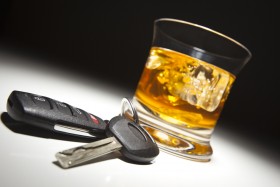 Glass of alcohol sitting beside a set of car keys
