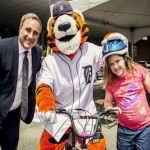 Scott Goodwin posing with Detroit Tigers mascot and girl with bike helmet on