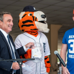 Two men and Detroit Tigers mascot pulling winners of raffle