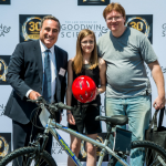 Scott Goodwin posing with a mountain bike, young girl and her dad