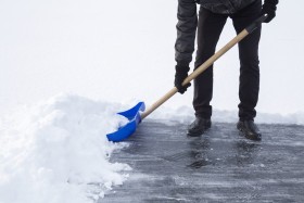 Man shoveling snow with blue snow shovel