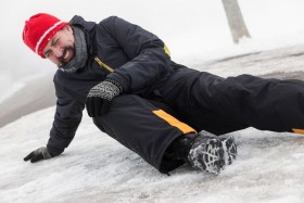 Man on ground grabbing knee in pain on snow