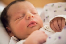 Newborn baby with dark hair sleeping