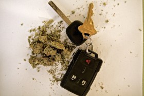 Pair of keys laying next to marijuana