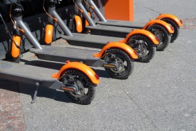 Grey and orange public electric scooters for rental