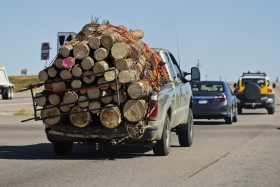 Truck driving on the road and overloaded with logs