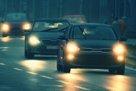 Cars driving with headlights on at nighttime