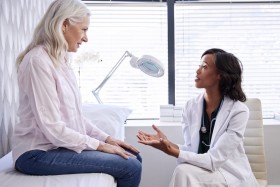 Female doctor talking to female patient in exam room