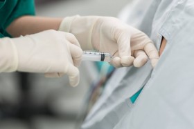 Anesthesiologist administering epidural shot to patient