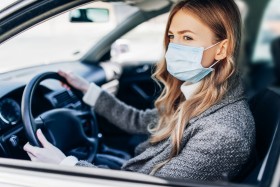 Woman driving while wearing a face mask.