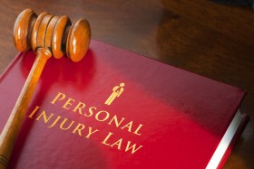 Personal injury law book with gavel on top
