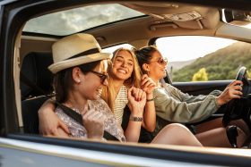 A group of teen girls in a car during a road trip.