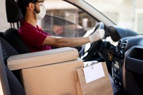 Packages are placed next to the driver in the front seat of a car while being delivered.