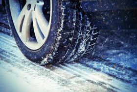 Close-up of a car tire on a snowy road.