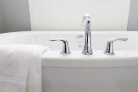 Side view of a white bathtub with a towel on the edge.