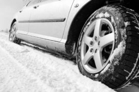 Close-up of a car's tires on a snowy road.